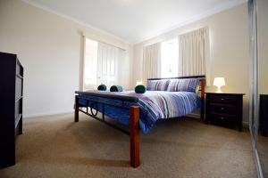 a bedroom with a bed and a dresser at Wavecrest Village & Tourist Park in Hopetoun