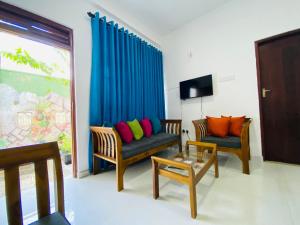 ein Wohnzimmer mit zwei Sesseln und einem Sofa in der Unterkunft TK Homes in Badulla