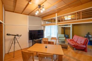 una sala de estar con una mesa y un sofá en 大切なペットと一緒に泊まれる一棟貸し, en Sado