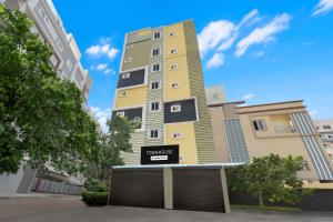 a tall yellow building with a sign on it at Super Townhouse Hitech City Madhapur in Hyderabad