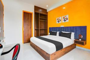 a bedroom with a large bed with an orange wall at Super Townhouse Sector 69 Gurgaon in Gurgaon