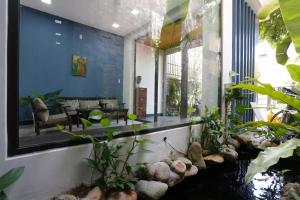 a living room with a large window and plants at Xanh Homestay in Da Nang