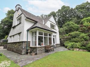 a white house with a large window on a lawn at Miyanli in Bowness-on-Windermere