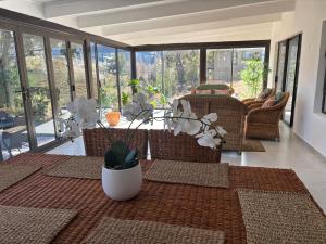 a living room with a table and chairs and windows at 105 Clarens Golf Villa in Clarens