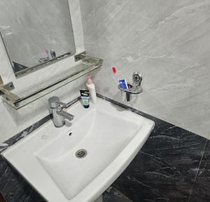 a bathroom sink with tooth brushes and a mirror at Mountain Pepper Palate Bed, Breakfast & Movie in Tokna +25 photos