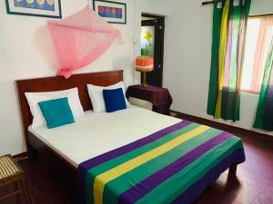 a bedroom with a bed with a colorful blanket at Jumera Villa Mirissa in Mirissa