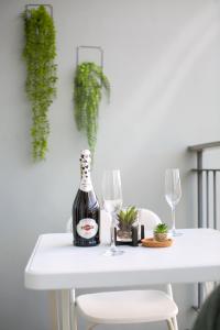 a bottle of wine on a white table with glasses at Cebu Central Charm Balcony City View - StoryStays in Cebu City