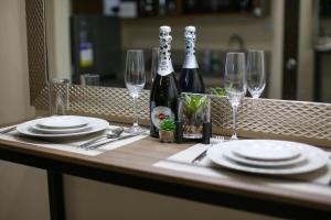 a table with plates and wine bottles and glasses at Cebu Central Charm Balcony City View - StoryStays in Cebu City