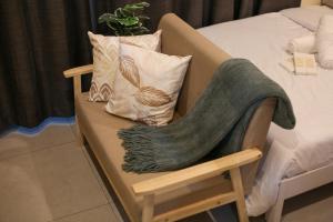 a couch with a blanket on it next to a bed at Cebu Central Charm Balcony City View - StoryStays in Cebu City