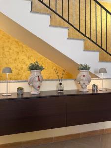 two vases sitting on a dresser under a staircase at Casa Marconi duplex avec terrasse in Aragona
