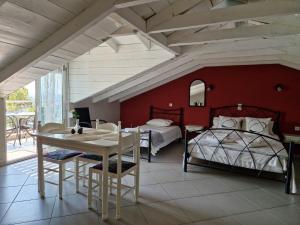 a bedroom with two beds and a table and a table and chairs at Maraki in Thymonia Beach