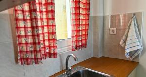 a kitchen with a sink and a window at Rachi Apartments in Nisís Léros