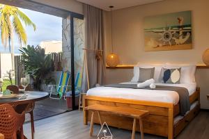 ein Schlafzimmer mit Bett und Tisch und ein Balkon in der Unterkunft Studio Alva na Praia de Lages, Rota dos Milagres in Tatuamunha + 57 Fotos