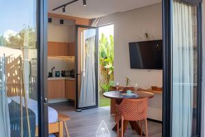 ein Wohnzimmer mit Tisch und Küche in der Unterkunft Studio Alva na Praia de Lages, Rota dos Milagres in Tatuamunha