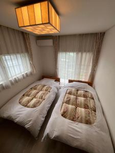 Una cama o camas en una habitación de iHouse あたみんち