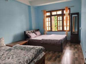 MirikにあるSweet Dream Homestayのベッド2台と窓のある寝室