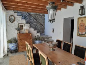 a dining room with a wooden table and chairs at Alex's Guesthouse with a pool in Dhomátia