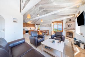 a living room with leather furniture and a fireplace at Villa Iremia Antipaxos in Antípaxos
