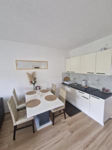 a kitchen with a table and chairs in a room at Apartman TESA in Sanski most
