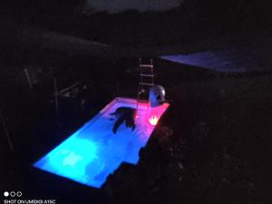 a man sitting on a surfboard in the dark at Gîtes du GRC in Campuac