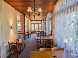 a restaurant with wooden ceilings and tables and chairs at Waldhuus Bellary in Grindelwald