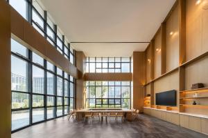 a large room with a table and some windows at Floral Hotel Banlan Cangzhou Convention and Exhibition Center High-speed Railway West Station in Zhifangtou