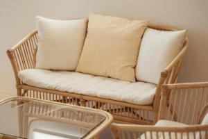 ein Schaukelstuhl aus Korbgeflecht mit zwei Kissen darauf in der Unterkunft Jeju Palm Spa Pool Villa in Jeju-do