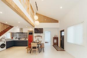 eine Küche und ein Wohnzimmer mit Tisch und Stühlen in der Unterkunft Jeju Palm Spa Pool Villa in Jeju-do