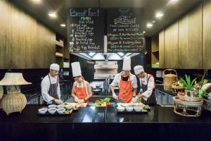 a group of chefs preparing food in a kitchen at Sunsuri Phuket - SHA Plus in Nai Harn Beach
