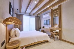 a hotel room with a bed and a desk at Club Kavala Beach Hotel Assos in Behramkale +63 photos