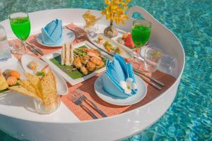 a tray of food on a table next to a pool at Sunsuri Phuket - SHA Plus in Nai Harn Beach