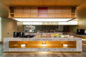 a kitchen with a counter with food on it at Floral Hotel Banlan Cangzhou Convention and Exhibition Center High-speed Railway West Station in Zhifangtou +25 photos