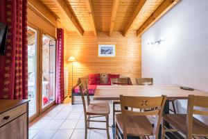 サン・フランソワ・ロンシャンにあるVg83 Chalet 6 ou 8 Couchagesのテーブルと椅子とソファのあるダイニングルーム