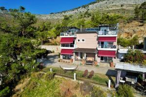 a large house with red trim on a hill at Maraki in Thymonia Beach