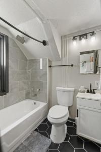 a bathroom with a toilet and a tub and a sink at 2BD Flat Near Cherokee Arts with Game Room vibes! in Saint Louis