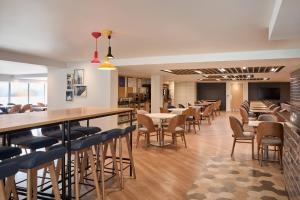 a restaurant with tables and chairs and a bar at Holiday Inn Express London Limehouse by IHG in London