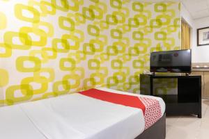 a bedroom with a bed and a wall with yellow and green patterns at Orange Nest Hotel in Manila +24 photos