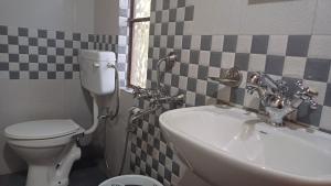 a bathroom with a white toilet and a sink at NA I BARIT EC homestay in Mawlynnong +12 photos