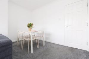 a table with two chairs and a potted plant on it at Central Bath Getaway House near Park in Bath