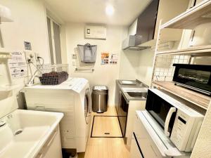 a kitchen with a stove and a microwave at Capital Shimbashi 101, Studio in Tokyo +34 photos