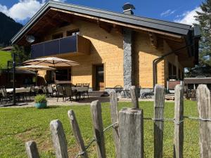 a wooden house with a fence in front of it at Sonn-Winkl in Mittelberg