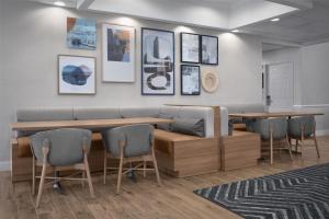 克兰福德Homewood Suites by Hilton Newark-Cranford的一间设有长凳和桌椅的等候室