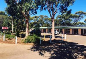 a motel with a sign in front of a building at Corrigin Windmill Motel in Corrigin