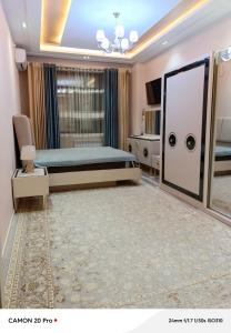 a bedroom with a bed and a large window at Cozy Stay in Dushanbe