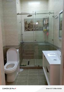 a bathroom with a shower and a toilet and a sink at Cozy Stay in Dushanbe