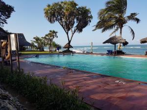 a swimming pool with the ocean in the background at Cliffside Amani Wooden Villa with Stunning Ocean Views for an Authentic Tanzanian Escape in Dar es Salaam