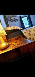 a wooden table with a lamp on top of a bed at Gîte Charme et Détente, Sauna, Spa,étang et Terrasse Privée in Gerbépal