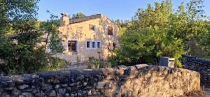 an old house behind a stone wall at Maison Provençale avec piscine in Estoublon