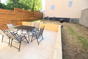 a patio with a table and chairs and a grill at Maison - Proche RER - Jusqu'à 6 Personnes in Saint-Michel-sur-Orge