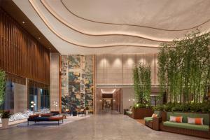 a lobby with couches and chairs in a building at Hilton Garden Inn Guiyang Gui'An New Area in Guiyang